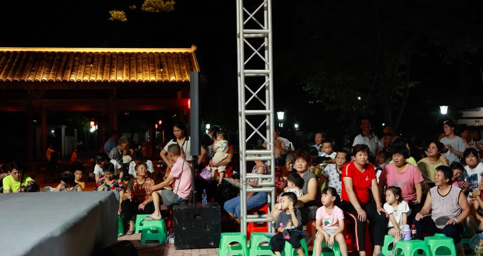 7月16日晚,村民們端坐成幾排,享受著“文化大餐”。(王琳雅 攝)